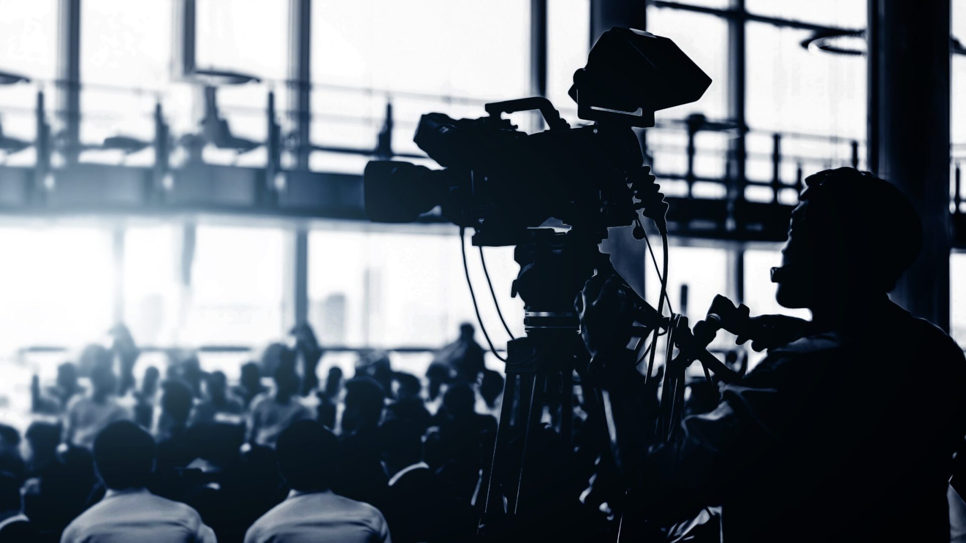 silhouette cameraman recording event with audient in black and white concept